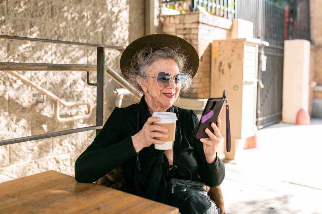 Ältere Dame mit Takeaway Kaffee
